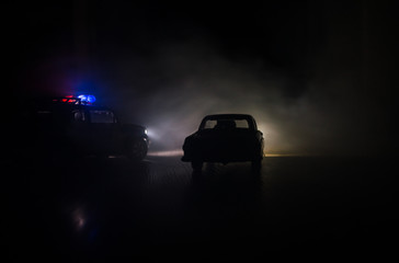 Fototapeta na wymiar Police car chasing a car at night with fog background. 911 Emergency response police car speeding to scene of crime