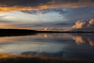 Naklejka na ściany i meble Sunset and clouds reflecting in a lake