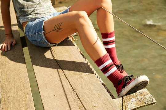 Girl's legs in socks on a hanging bridge over a mountain river in Abkhazia