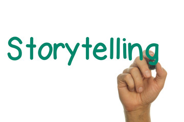 Hand writing the word Storytelling  in Green on Screen