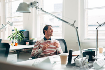 Portrait of happy attractive businessman at meeting at work smiling