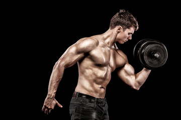 Fototapeta na wymiar Athletic shirtless young sports man - fitness model holds the dumbbell in gym. Copy space fore your text.