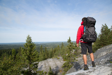 Hiker stands on the summit from Akka-Koli and enjoys the natural landscape, summer 