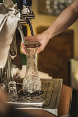 Young bartended cleaning a beer pint