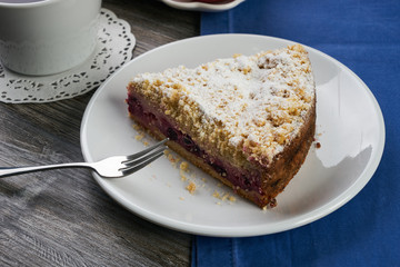Vegan, raw berry cake on plate and cup of tea