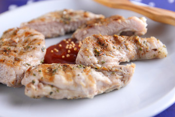 Steaks with grill on a white plate with a wooden fork, tomato sauce, spices and grains of mustard on a dark blue background in retro style