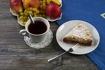 Vegan, raw berry cake on plate and cup of tea
