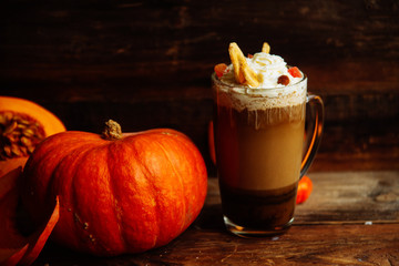 Pumpkin smoothie, spice latte. Boozy cocktail with whipped cream on top on a wooden background. Copy space Top view