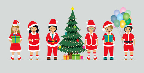 Schoolboy in Santa Claus costume with Christmas tree and gift