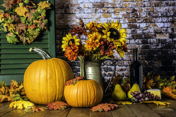 orange pumpkins fall flowers autumn leaves and bottle of wine on wood deck