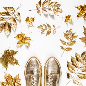 Autumn composition. Pattern made of autumn golden  leaves and stylish shoes on  white background. Flat lay, top view