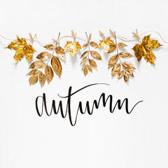 Autumn composition. Clothespins on the rope holding autumn golden leaves on a white background.