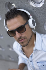 Obraz premium Portrait of a young man listening music with earphones