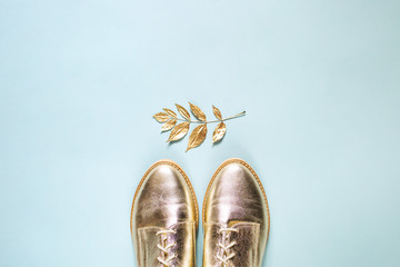 Autumn golden  leaves and stylish shoes on  blue background. Flat lay, top view