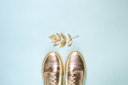 Autumn golden  leaves and stylish shoes on  blue background. Flat lay, top view