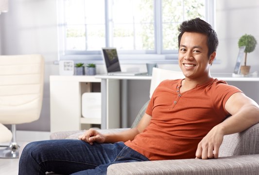 Handsome Asian man at home smiling