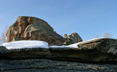 The snow-covered fantastic rock on the sunny day. 