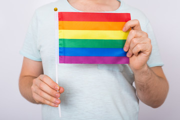 Male holding the rainbow flag close up. Concept of sexual minority and LGBT