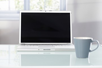 Closeup photo of laptop and tea mug
