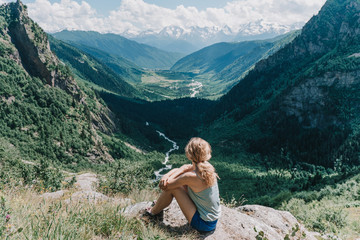 Naklejka premium young girl meditates on a background of mountains