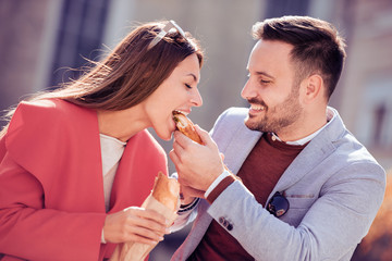 Happy young couple,eating sandwich and having a great time.