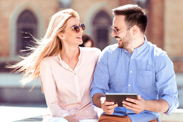 Couple using a digital tablet in city