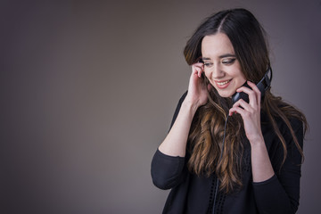 Young woman holding earphones, listening to her favourite music and smiling