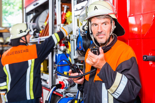 Einsatzleiter bei der Feuerwehr checkt Funkger&auml;t