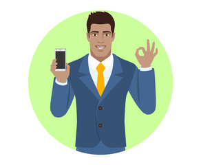 Businessman holding mobile phone and show a okay hand sign