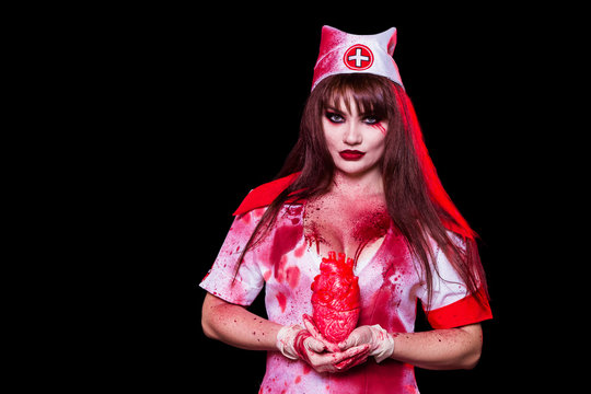 A beautiful, sexy woman, a vampire, a nurse all in the blood, a cutout on her chest holding a human heart. Kill the killer, mania, canibal