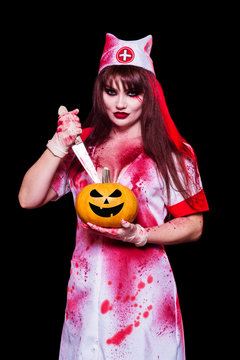 A beautiful, sexy woman, a vampire, a nurse all in the blood, a cutout on her chest holding a knife and a pumpkin. Kill the killer, mania, canibal