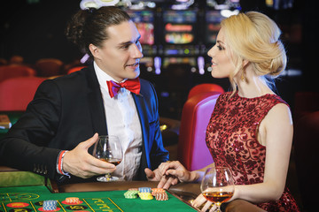 Beautiful and rich couple playing roulette in the casino