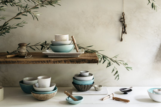 Close-up collection of modern handmade ceramic bowls, plates and cups. Asian statuette