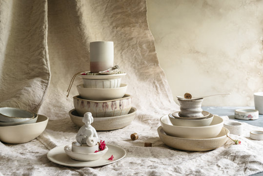 Close-up of handmade ceramic collection bowls, plates and cups. Asian statuette