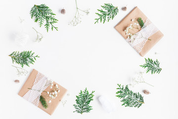 Christmas composition. Christmas gifts, pine cones, gypsophila flowers, thuja branches on white background. Flat lay, top view, copy space