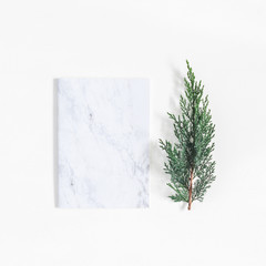 Christmas minimal composition. Marble notebook and pine branches on white background. Christmas, winter, new year concept. Flat lay, top view, copy space, square