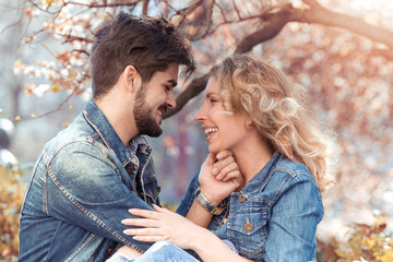 Loving couple under a big tree in the park in spring