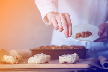 Obraz na płótnie Canvas Female chef cooking sweet baking dishes
