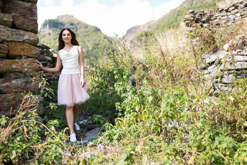 Young woman near a stone wall