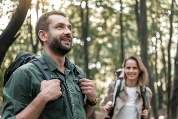 Joyful couple walking in the woods with enjoyment