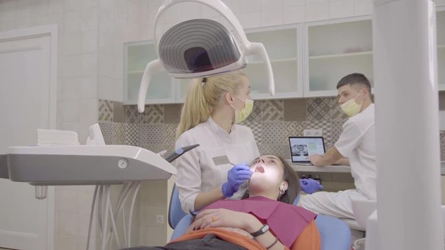 Female dentist curing a young attractive woman