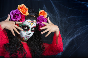 Sugar Skull little girl Halloween costume and makeup. Portrait of a little girl with Halloween costume and makeup of Sugar Skull with white painted face, roses