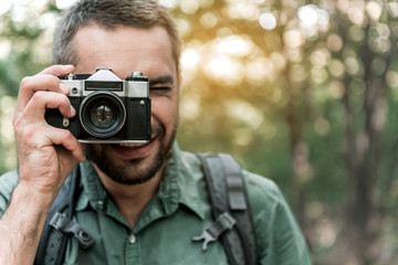 Happy man photographing nature in the woods