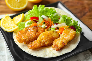 Plate with delicious fish taco on table, closeup
