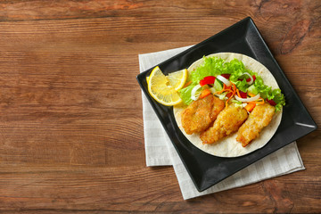 Plate with delicious fish taco on wooden table