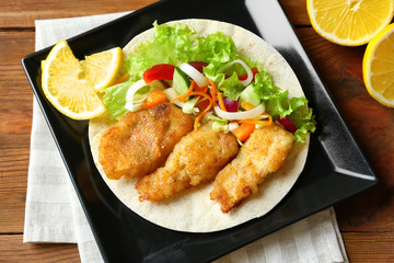 Plate with delicious fish taco on table, closeup