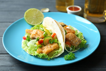 Plate with delicious fish tacos on table, closeup