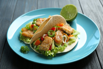 Plate with delicious fish tacos on table, closeup