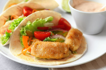 Plate with delicious fish tacos on table, closeup