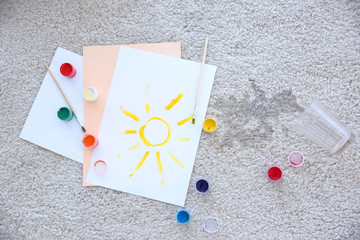 Picture, paints and spilled water on carpet